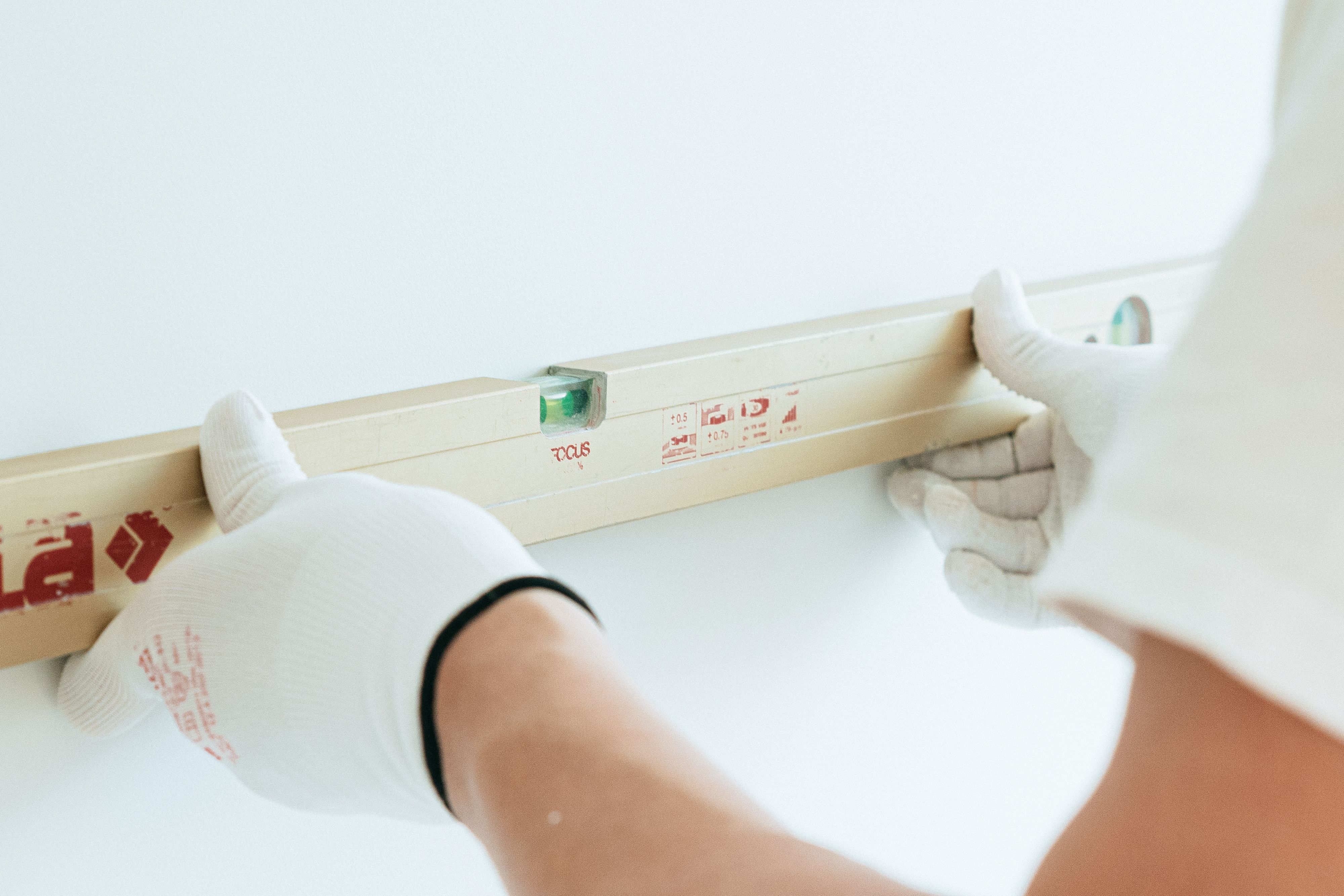 Craftsman checking wall level with a precision spirit level during renovation